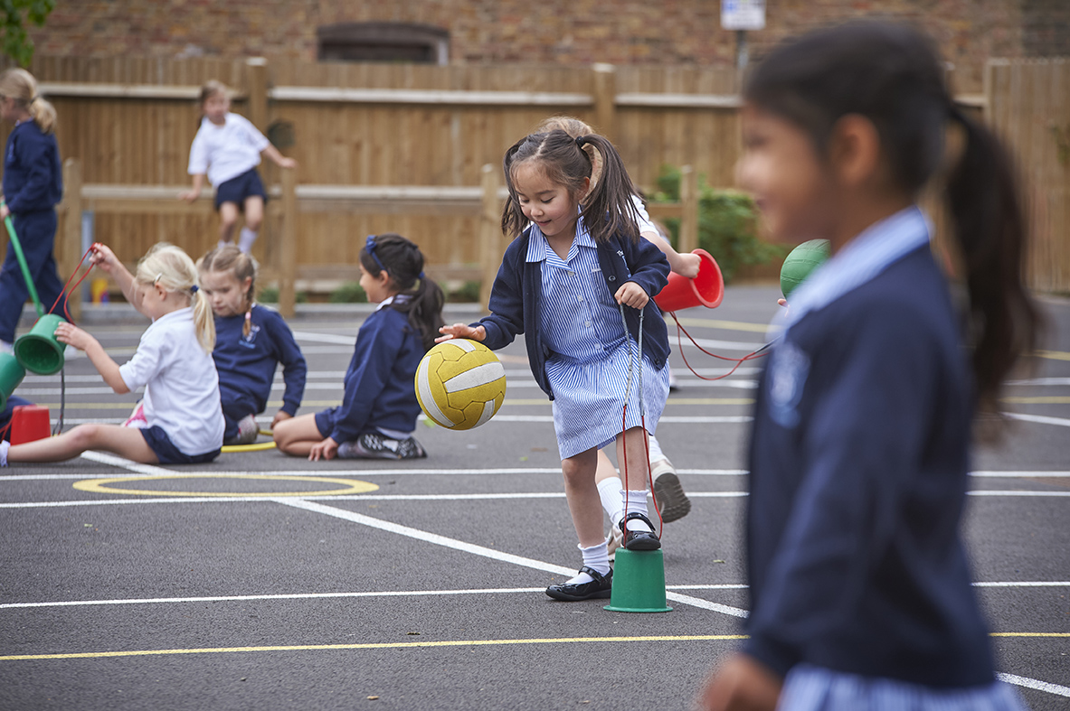 Study girl playing with football in Wilberforce House playground