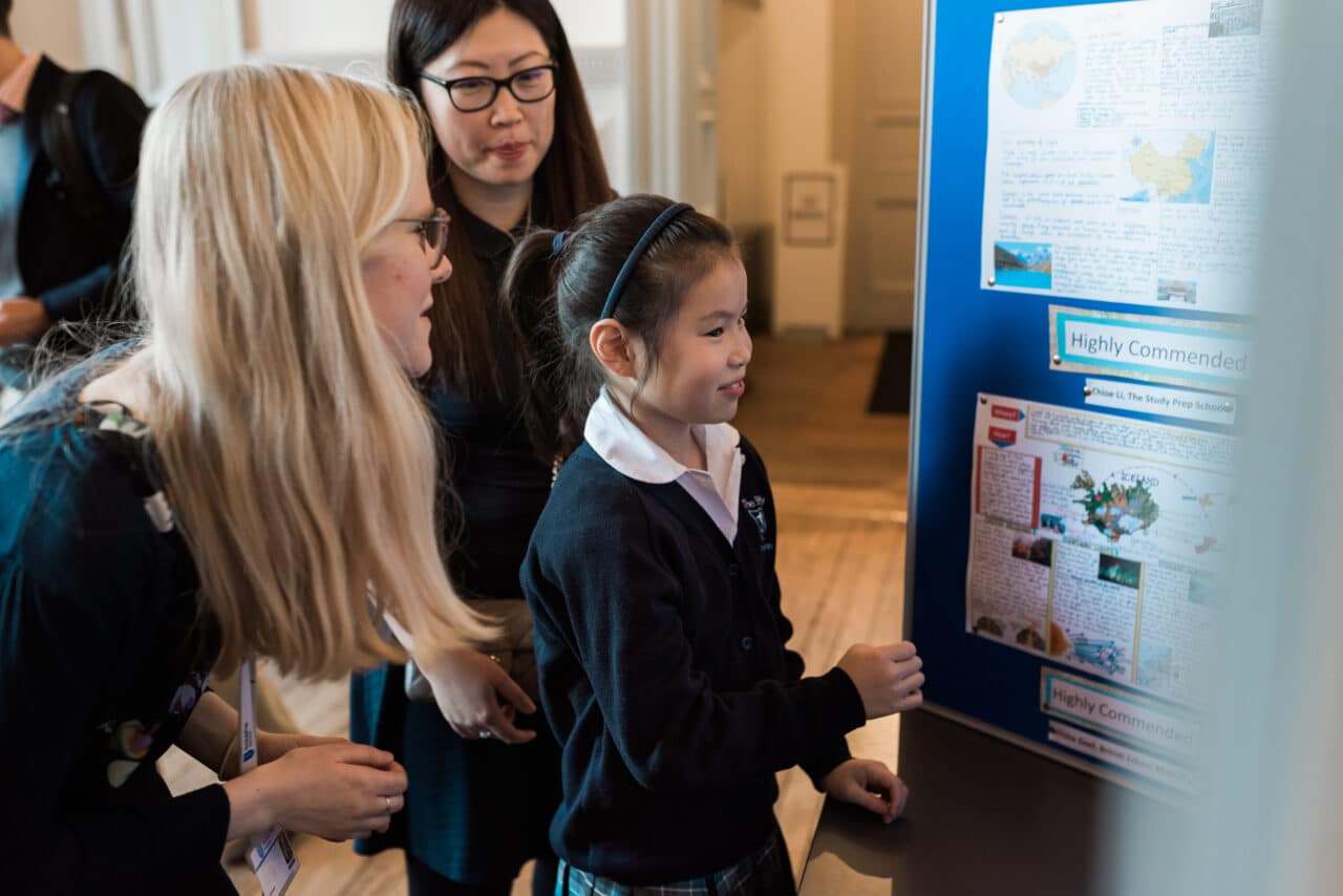 Chloe sees her poster displayed in the Royal Geographic Society